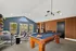 Chic game room with elegant pool table, plush seating area, and stylish dart machines, perfect for entertainment and relaxation.