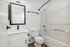 Sleek modern bathroom with elegant fixtures, a large mirror, and a pristine bathtub, perfect for relaxation.