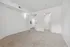 Bright and inviting bedroom with plush carpet and modern white walls, leading to a spacious walk-in closet and kitchen entrance.