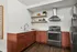 Chic modern kitchen with sleek stainless steel appliances, warm copper-toned cabinets, and elegant open shelving.