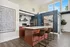 Elegant modern kitchen with stylish dark accents, featuring a spacious island, sleek cabinetry, and ample natural light from large windows.
