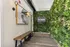 Modern apartment entrance featuring lush green vertical garden and chic wall art at ReNew West Bloomington.