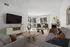 Bright and modern living room featuring sleek furniture, elegant decor, and large windows allowing natural light to flow in.