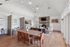 Elegant living space with high ceilings, cozy brick fireplace, and modern decor, perfect for entertaining.