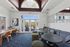 Chic community lounge with plush seating, modern decor, and large windows opening to a scenic outdoor patio.