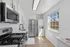 Modern kitchen featuring sleek stainless steel appliances, ample cabinetry, and in-unit washer and dryer under natural light.