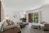 Inviting living room with plush seating, elegant décor, and sliding glass doors opening to a serene balcony view.