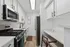 Sleek minimalist kitchen with modern stainless steel appliances and elegant white cabinetry, featuring a cozy breakfast nook and stylish decor.