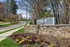 Charming entrance of reNEW Howard Crossing with vibrant flower beds and lush greenery, offering a welcoming and serene ambiance.