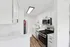 Modern kitchen with sleek appliances, bright lighting, and elegant white cabinetry.