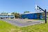 Inviting community basketball court surrounded by charming townhomes and a vibrant recreational center under a clear blue sky.