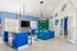 Modern living room with vibrant blue couches, stylish pendant lighting, and open-concept design ideal for entertaining.