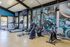 Bright and modern gym equipped with treadmills, exercise bikes, and vibrant industrial art, ideal for fitness enthusiasts.