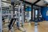 Modern gym facility featuring state-of-the-art fitness equipment and free weights, complemented by spacious interiors for optimal workouts.