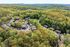 Charming aerial view of an apartment complex nestled in lush green forests, offering a serene and picturesque living environment.