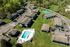 Expansive apartment complex with lush greenery, a sparkling swimming pool, ample parking, and sports facilities for vibrant community living.