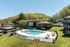 Inviting apartment complex with a sparkling outdoor pool, surrounded by lush greenery and modern buildings, perfect for relaxation and enjoyment.