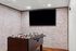 Chic recreational room featuring a foosball table and large TV against a stylish brick wall, perfect for entertainment.