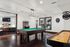 Vibrant game room featuring a pool table, arcade machine, shuffleboard, and dart board, perfect for entertainment and relaxation.