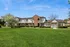 Charming apartment complex with brick architecture and lush green lawn under a clear blue sky.