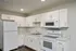Modern kitchen with sleek white cabinetry, elegant marble countertops, and stainless steel appliances.