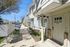 Charming townhouse exterior with classic brick accents, inviting entrance, and a well-maintained sidewalk on a sunny day.