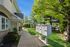 Charming residential walkway with lush greenery and convenient mailbox stations, leading to welcoming apartment entrance.