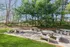 Charming outdoor area with stone picnic tables surrounded by lush green trees, offering a serene escape for relaxation and gatherings.