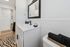 Chic bathroom with sleek white vanity, stylish black fixtures, and elegant tiled walls for a modern touch.