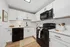 Modern kitchen with sleek black appliances, white shaker cabinets, and elegant marble countertops, exuding contemporary charm.