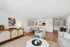Charming living area with modern decor, open dining space, and cozy seating, featuring a stylish console and art pieces.