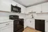 Modern kitchen with sleek black appliances, white cabinetry, and elegant marble countertops.