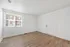 Bright interior showcasing sleek hardwood floors and a large window with natural light, perfect for a welcoming entryway or cozy living space.