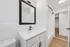 Modern bathroom with sleek black fixtures, large framed mirror, and elegant white countertop offering a clean and sophisticated look.