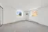 Bright and airy room showcasing soft carpet flooring and large windows for natural light.