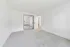 Bright, airy bedroom with fresh white walls, plush carpet, and mirrored closet doors reflecting natural light.
