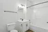Modern, bright bathroom featuring sleek white fixtures, elegant vanity with black accents, and a spacious bathtub with contemporary design.