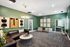 Chic lounge area with stylish green walls, modern art, and elegant lighting, perfect for relaxation and entertaining.