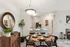 Contemporary dining area with elegant wooden table set for four, adjacent to a stylish kitchen and cozy living space with a warm fireplace.