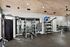 Modern fitness center with state-of-the-art gym equipment, including weights and resistance machines, under a stylish wooden ceiling.
