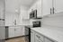Sleek modern kitchen featuring pristine white cabinetry, elegant marble countertops, and premium stainless steel appliances.