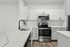 Modern kitchen with sleek white cabinetry, elegant marble countertops, and stainless steel appliances for a refined living space.