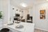 Modern kitchen with sleek white cabinets, stainless steel appliances, and a stylish breakfast bar with elegant table settings.