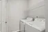 Bright and functional laundry room featuring a modern washer and dryer with convenient shelf space.