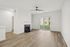 Bright and modern living room with elegant hardwood floors, stylish fireplace, and large sliding doors opening to a lush garden view.