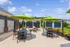 Chic outdoor patio area featuring vibrant green umbrellas and modern seating, perfect for relaxing and entertaining guests.