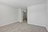 Bright and spacious room with plush carpeting and mirrored closet doors, offering a modern and versatile layout for personalization.