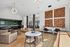 Open-concept living space featuring stylish furniture, artistic wall decor, and a sleek kitchen in a spacious modern apartment.