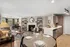 Modern open-concept apartment with cozy living area, elegant dining space, and sleek kitchen featuring a stylish fireplace, contemporary shelving, and large windows offering natural light.