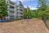 Charming apartment building with elegant balconies and lush green surroundings, featuring a spacious play area ideal for families.